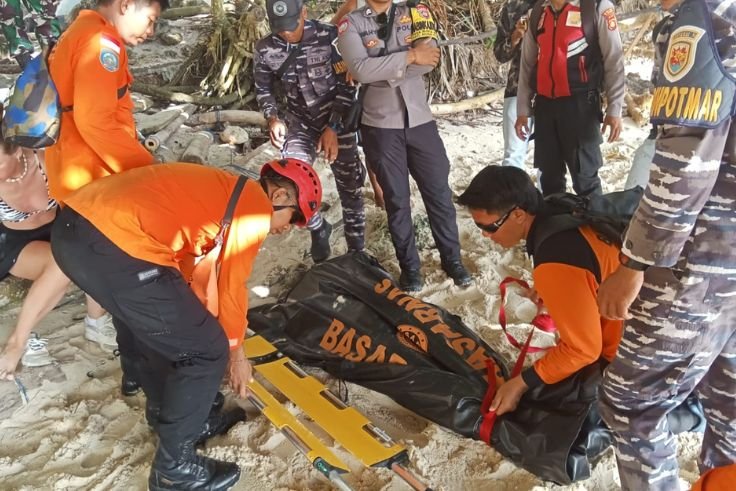 Rescue teams evacuate the body of a French tourist swept away by strong waves at Kelingking Beach, Nusa Penida.