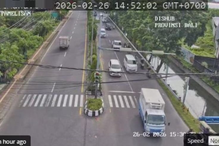 Traffic monitoring at Simpang Pamelisan shows vehicles moving smoothly away from the camera toward Jl By Pass Ngurah Rai heading to Kuta.